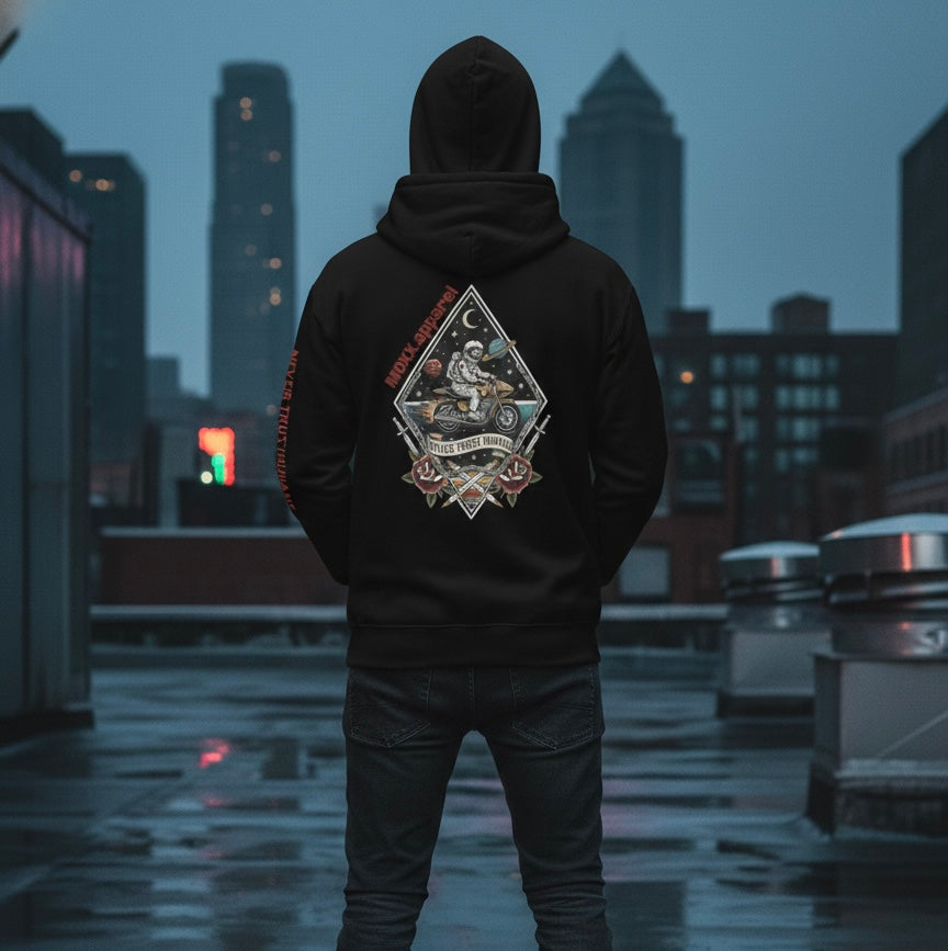 Person wearing a black hoodie with a graphic design on the back, standing on a rooftop with city skyline in the background.