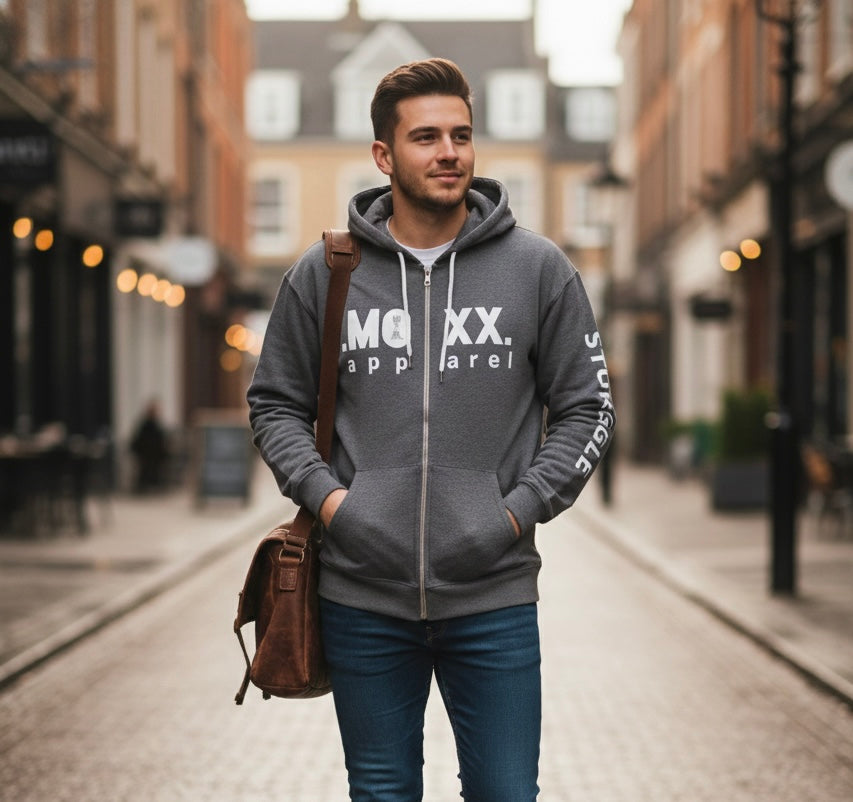 Man wearing a gray hoodie with branding on a city street