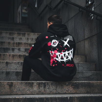 Black hoodie with graphic design and red splashes on a wooden background with 'MOXXapparel.com' text.